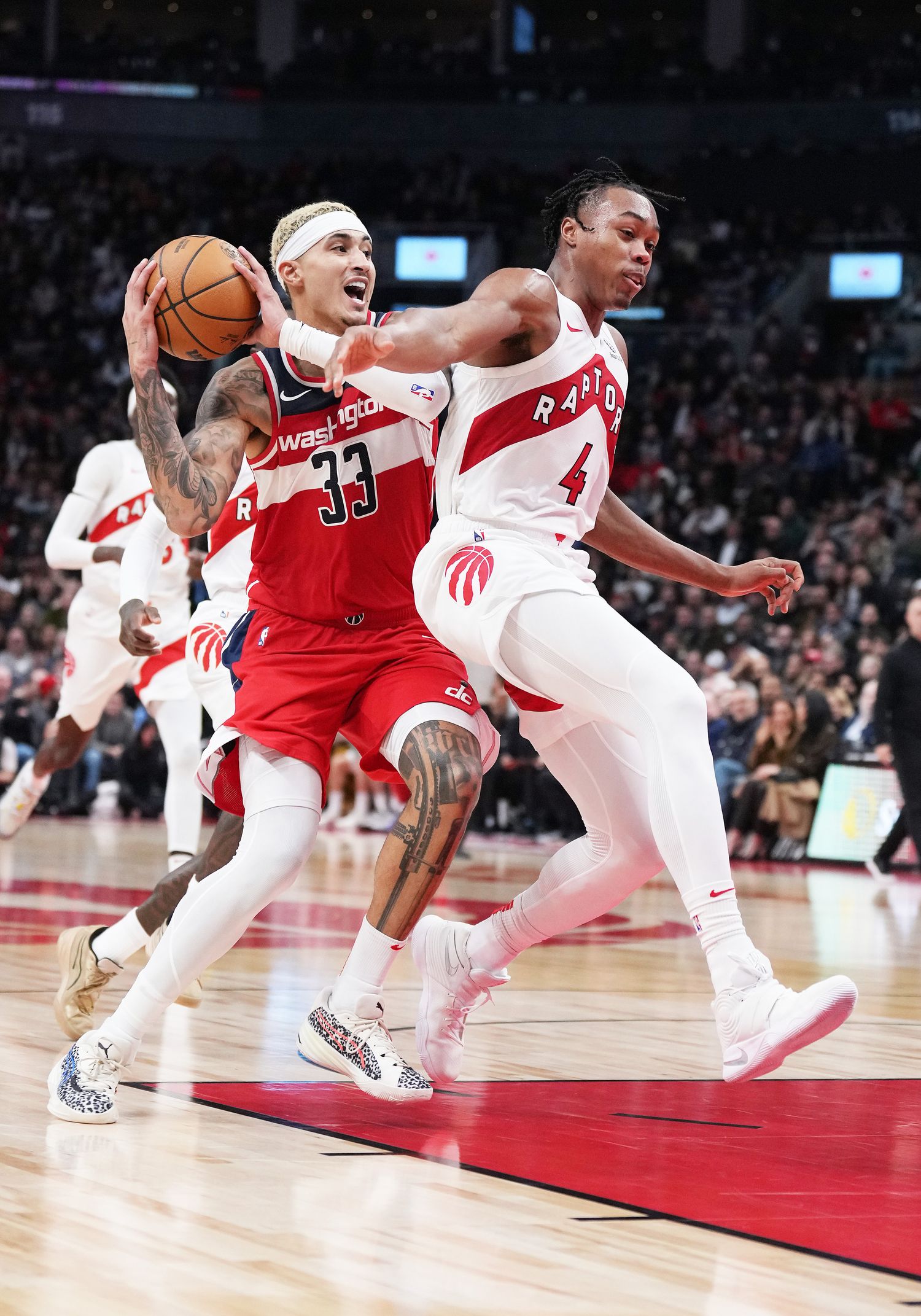 Washington Wizards forward Kyle Kuzma (33) battles for the ball with Toronto Raptors forward Scottie Barnes (4) during the fourth quarter at Scotiabank Arena. 